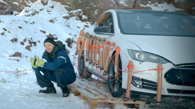핀란드의 한 남성이 자신이 소유한 테슬라 전기차 모델S 차량의 배터리 교체 비용이 너무 비싸다는 이유로 차량을 폭파하는 장면을 공개했다. 폭파 전문가가 다이너마이트를 장착하고 기념 촬영을 하는 모습. 유튜브 캡처