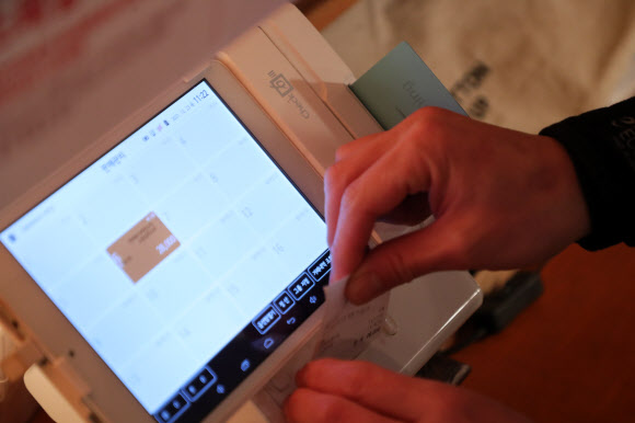 더불어민주당과 정부는 23일 연 매출 3억원 이하 가맹점에 대해 신용카드 수수료를 기존 0.8%에서 0.5%로 낮추기로 했다. 연 매출 30억원 이하 카드 가맹점 대상으로도 수수료가 조금씩 인하되며 전체 가맹점 가운데 96%가 수수료 인하 혜택을 볼 전망이다. 사진은 이날 서울 시내 한 식당에서 카드 결제하는 모습. 2021.12.23 연합뉴스