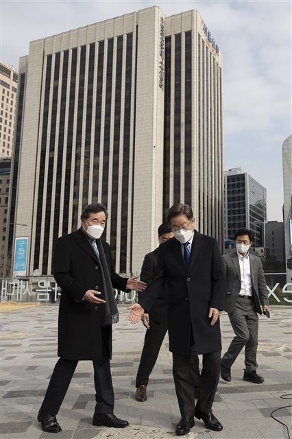 이재명 더불어민주당 대선후보와 이낙연 전 대표가 23일 정오 서울 중구 달개비에서 오찬회동을 마친 뒤 인근에 있는 서울도시건축관으로 이동해 서로에게 회견 자리를 권하고 있다. 2021.12.23 뉴스1