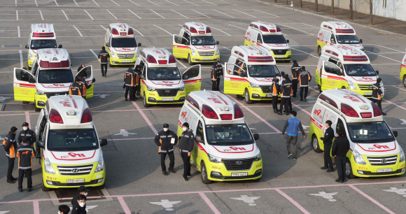 소방청의 동원령으로 서울지역 코로나19 환자 이송 지원을 위해 전국에서 동원된 구급차와 구급대원들이 23일 서울 송파구 서울종합운동장에 집결 후 이동할 준비를 하고 있다. 소방청에 따르면 이번 동원령으로 전국 8개 시·도 소속 24대의 구급차와 구급대원 96명이 소집됐다. 이들은 서울지역 소방서 24곳에 1대씩 분산 배치되며, 코로나19 환자 이송업무를 분담할 예정이다. 2021. 12. 23 안주영 전문기자 jya@seoul.co.kr