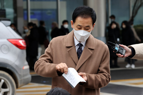 박근혜 전 대통령의 변호인인 유영하 변호사가 24일 서울 강남구 삼성서울병원 앞에서 특별사면·복권된 박 전 대통령의 입장이 적힌 노트를 취재진에게 보여주고 있다.  국정농단 사건 등으로 유죄 확정을 받아 수감 중인 박 전 대통령은 이날 특별사면·복권됐다. 2021.12.24 연합뉴스