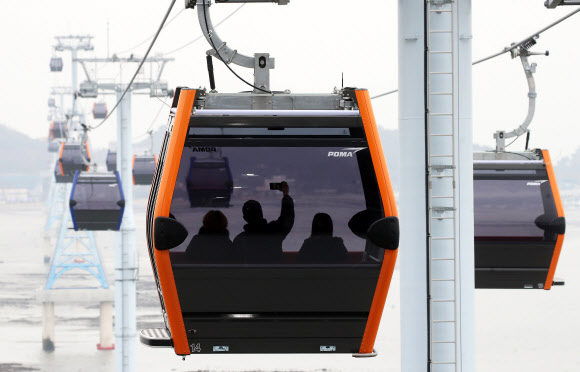 24일 경기도 화성시 ‘서해랑 제부도해상케이블카’에서 시민들이 케이블카를 타고 겨울 바다를 바라보고 있다. 지난 23일 정식 운영을 시작한 ‘서해랑 제부도해상케이블카’는 전곡항에서 제부도에 이르는 2.12km 해상구간을 한 번에 최대 10명까지 탑승 가능한 케빈 41대로 시간당 최대 1천500명을 수송할 수 있다. 2021.12.24 연합뉴스