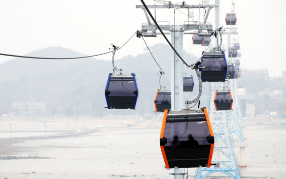 24일 경기도 화성시 ‘서해랑 제부도해상케이블카’에서 시민들이 케이블카를 타고 겨울 바다를 바라보고 있다. 지난 23일 정식 운영을 시작한 ‘서해랑 제부도해상케이블카’는 전곡항에서 제부도에 이르는 2.12km 해상구간을 한 번에 최대 10명까지 탑승 가능한 케빈 41대로 시간당 최대 1천500명을 수송할 수 있다. 2021.12.24 연합뉴스