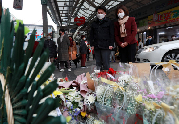 국민의당 안철수 대선 후보와 부인 김미경 교수가 24일 오후 부산 수영구 수영팔도시장을 찾아 할머니와 손녀가 숨진 차량 돌진사고 현장에서 묵념하고 있다. 2021.12.24 연합뉴스