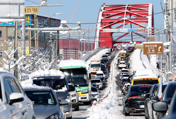 강원 동해안 지역에 밤새 많은 눈이 내린 25일 속초시 설악대교로 향하는 도로가 극심한 혼잡 현상을 빚고 있다. 2021.12.25 연합뉴스