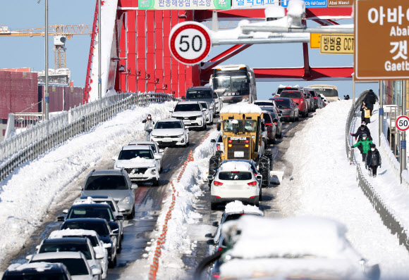 강원 동해안 지역에 밤새 많은 눈이 내린 25일 속초시 설악대교로 향하는 도로가 극심한 혼잡 현상을 빚고 있다. 2021.12.25 연합뉴스