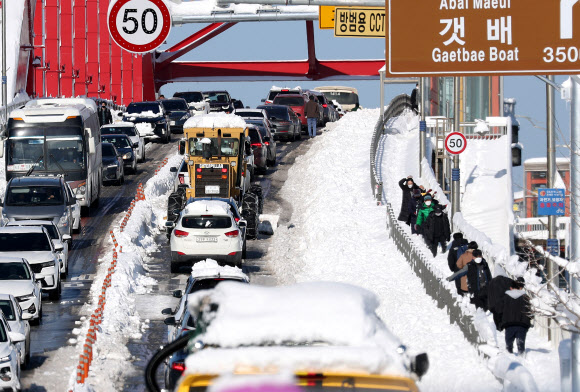 강원 동해안 지역에 밤새 많은 눈이 내린 25일 속초시 설악대교로 향하는 도로가 극심한 혼잡 현상을 빚고 있다. 2021.12.25 연합뉴스