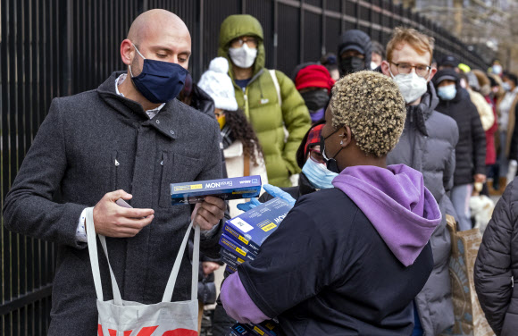 지난 23일(현지시간)미국 뉴욕에서 시민들이 길게 줄을 서서 당국이 무료로 배포하는 코로나19 간이진단키트를 받고 있다. AP