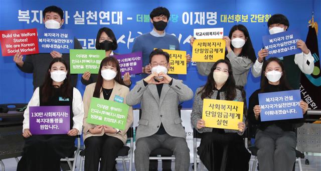 이재명 더불어민주당 대선 후보가 28일 오전 서울 영등포구 한국사회복지사협회에서 열린 복지국가실천연대와의 간담회에서 청년사회복지사들과 함께 기념촬영을 하고 있다. 2021.12.28 국회사진취재단