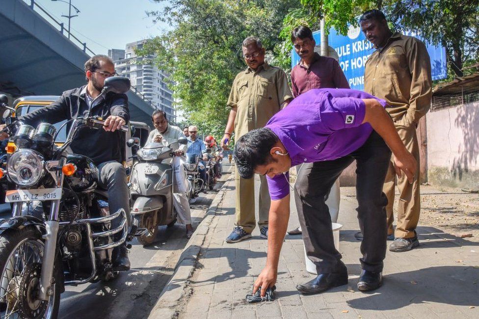 인도의 몇몇 도시에서는 걷다가 침을 뱉었다는 이유로 길바닥에 눌러붙은 껌자국 등을 떼내는 벌칙을 부과하기도 한다. AFP 자료사진