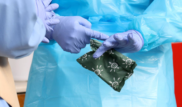 28일 경기도 성남시 국군수도병원 응급실 앞에서 한 의료진이 핫팩으로 잠시나마 추위를 녹이고 있다. 2021.12.28 연합뉴스