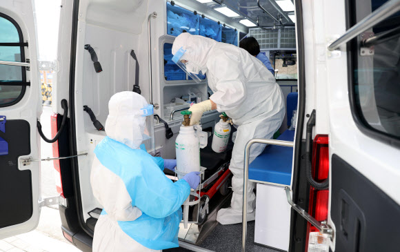 28일 경기도 성남시 국군수도병원 응급실에서 의료진이 코로나19 확진 환자 이송을 위해 구급차 내부를 정리하고 있다. 2021.12.28 연합뉴스