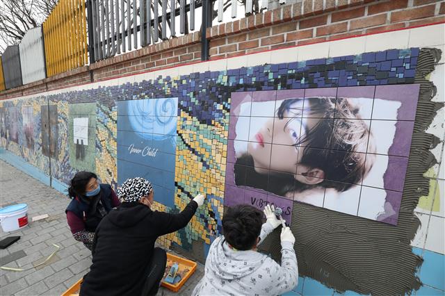 방탄소년단(BTS)의 멤버 ‘뷔(본명?김태형)’의 생일을 앞두고 28일 오후 모교인 대구 서구 비산동 대성초등학교 외벽에 높이 2m 길이 33m 크기의 초대형 파노라마 타일벽화 설치가 한창이다. 벽화 설치는 중국 최대 뷔 팬클럽 ‘바이두뷔바(baidu v bar)’와 BTS 소속사 빅히트 뮤직, 대구 서구 간 협조로 진행됐다. 벽화는 뷔의 생일(12월30일) 전날인 29일 준공될 예정이지만 한파로 일정이 다소 늦어지고 있다. 2021.12.28  뉴스1