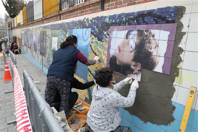 방탄소년단(BTS)의 멤버 ‘뷔(본명?김태형)’의 생일을 앞두고 28일 오후 모교인 대구 서구 비산동 대성초등학교 외벽에 높이 2m 길이 33m 크기의 초대형 파노라마 타일벽화 설치가 한창이다. 벽화 설치는 중국 최대 뷔 팬클럽 ‘바이두뷔바(baidu v bar)’와 BTS 소속사 빅히트 뮤직, 대구 서구 간 협조로 진행됐다. 벽화는 뷔의 생일(12월30일) 전날인 29일 준공될 예정이지만 한파로 일정이 다소 늦어지고 있다. 2021.12.28 뉴스1