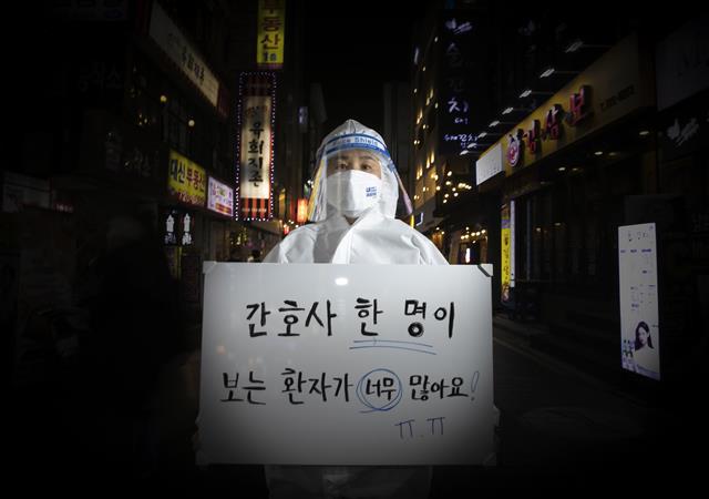 올해도, 여전히 신종 코로나바이러스 감염증(코로나19)의 한해였다. 백신 접종률이 높아짐에 따라 일상 회복에 대한 기대감이 높았지만 연이은 돌파 감염에 오미크론 변이까지 발생하며 위드코로나는 요원해지고 있다. 공공운소노조 의료연대본부 소속 김혜정 간호사가 네온사인이 빛나는 종로 유흥가에 새해 소원을 들고 섰다. 김민정 간호사는 새해 소망을 화이트보드에 적어달라는 부탁에 개인적 소망보다 코로나19 현장에서의 구조적 문제를 해결하고 싶다고 말했다. 간호사 한 명에게 주어진 환자가 너무 많아 식사와 화장실을 포기하면서까지 바쁘게 뛰어다니지만 결국에는 환자를 제대로 간호하지 못했다는 죄책감에 시달리게 되고, 묵묵히 일하던 동료가 결국 환자 곁을 떠나게 되는 일이 발생하고 있다며 아쉬움을 드러냈다. 다가오는 2022년 임인년(壬寅年)에는 의료진들이 바라는 것처럼 의료진이 환자들에게 전념할 수 있도록 간호사 한 명당 환자수가 줄어들기를 바란다. 또한 의료진도 사진 속에서 이들을 스쳐가는 평범한 사람들처럼 가족들과 만나고 친구들과 함께 술잔을 부딪칠 수 있는 한 해가 되길 희망한다. 2021.12.29  뉴스1