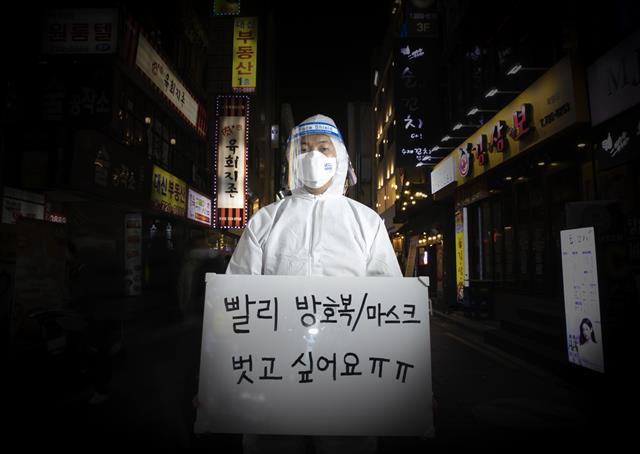 올해도, 여전히 신종 코로나바이러스 감염증(코로나19)의 한해였다. 백신 접종률이 높아짐에 따라 일상 회복에 대한 기대감이 높았지만 연이은 돌파 감염에 오미크론 변이까지 발생하며 위드코로나는 요원해지고 있다. 공공운소노조 의료연대본부 소속 김별샘 병원노동자가 네온사인이 빛나는 종로 유흥가에 새해 소원을 들고 섰다. 새해 소망을 화이트보드에 적어달라는 부탁에 코로나19가 내년에도 끝나지 않을 것 같다고 말하면서도 마스크와 방호복을 벗고 싶다고 적었다. 다가오는 2022년 임인년(壬寅年)에는 의료진이 유흥가를 찾는 평범한 사람들처럼 가족들과 만나고 친구들과 함께 술잔을 부딪칠 수 있는 한 해가 되길 희망한다. 2021.12.29  뉴스1