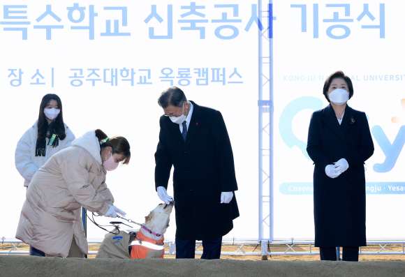 문재인 대통령이 29일 충남 공주시 공주대학교 옥룡캠퍼스에서 열린 공주대학교 부설 특수학교 설립 기공행사에 참석해  시각장애인  박솔이 공주대학교 특수교육학과  학생과 함께 온 이름이 평화인 안내견의 재롱을 보고 있다. 2021. 12. 29 도준석 기자 pado@seoul.co.kr