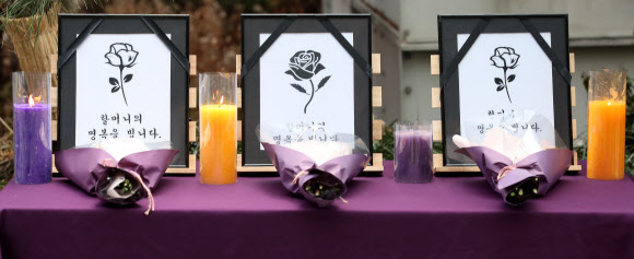 29일 오후 서울 종로구 옛 일본대사관 앞에서 열린 ‘1524차 일본군성노예제 문제해결을 위한 정기 수요시위’에서 2021년 돌아가신 세 분의 피해자 할머니를 위한 추모 꽃다발이 놓여 있다. 2021.12.29  연합뉴스