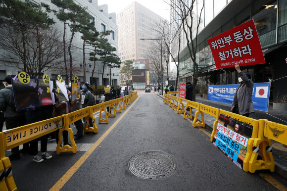 29일 오후 서울 종로구 옛 일본대사관 앞에서 열린 ‘1524차 일본군성노예제 문제해결을 위한 정기 수요시위’ 참가자들이 극우단체를 향해 양심거울을 들어보이고 있다. 2021.12.29  연합뉴스