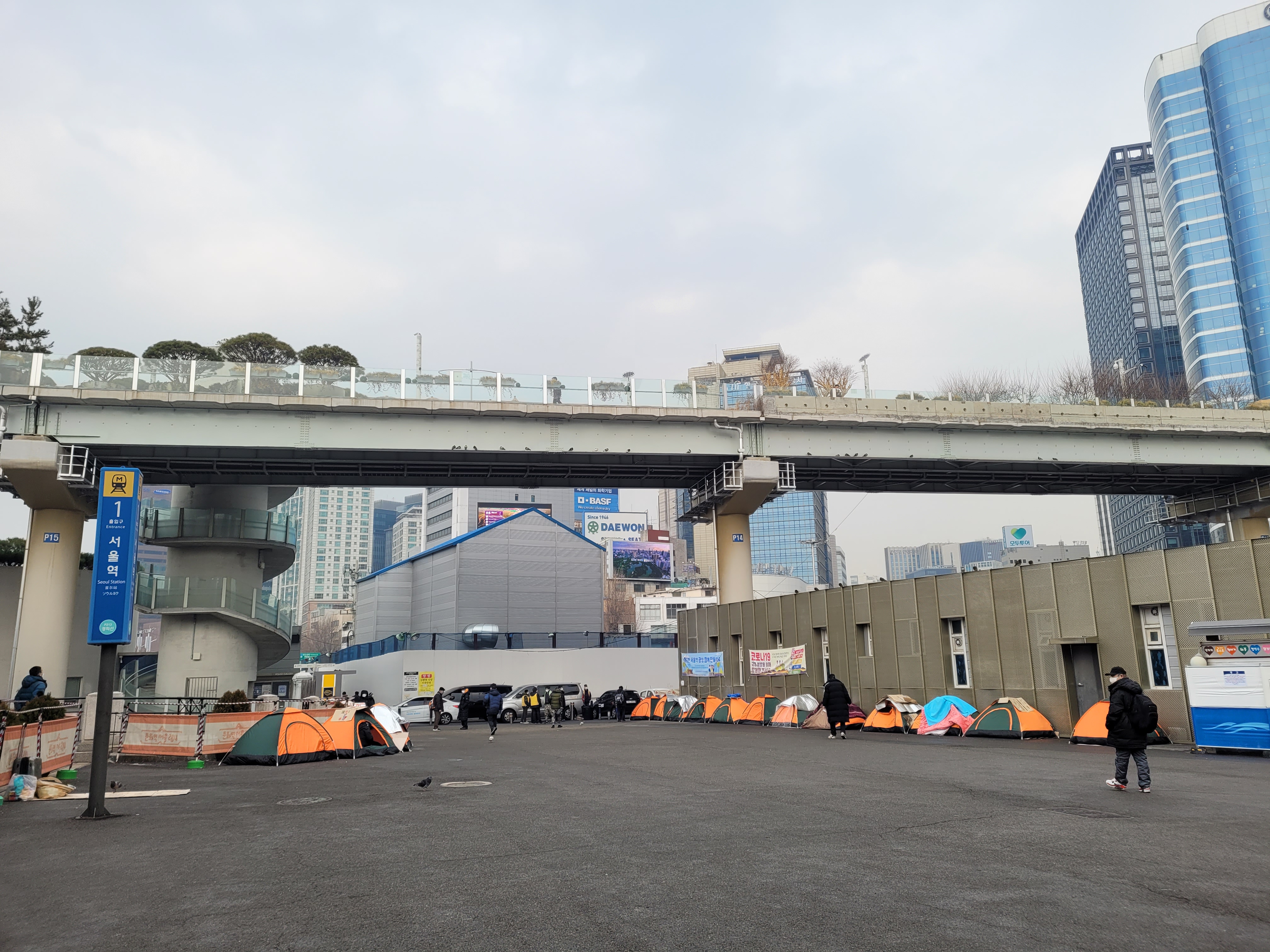 지하철 1호선 서울역 1번과 2번 출구 사이 광장 양옆으로 지난달 29일 텐트 20여개가 나란히 서 있다. 노숙인들의 한파 대비와 코로나 방역을 위한 임시 조치로 교회나 시민단체 등에서 마련한 것이다.