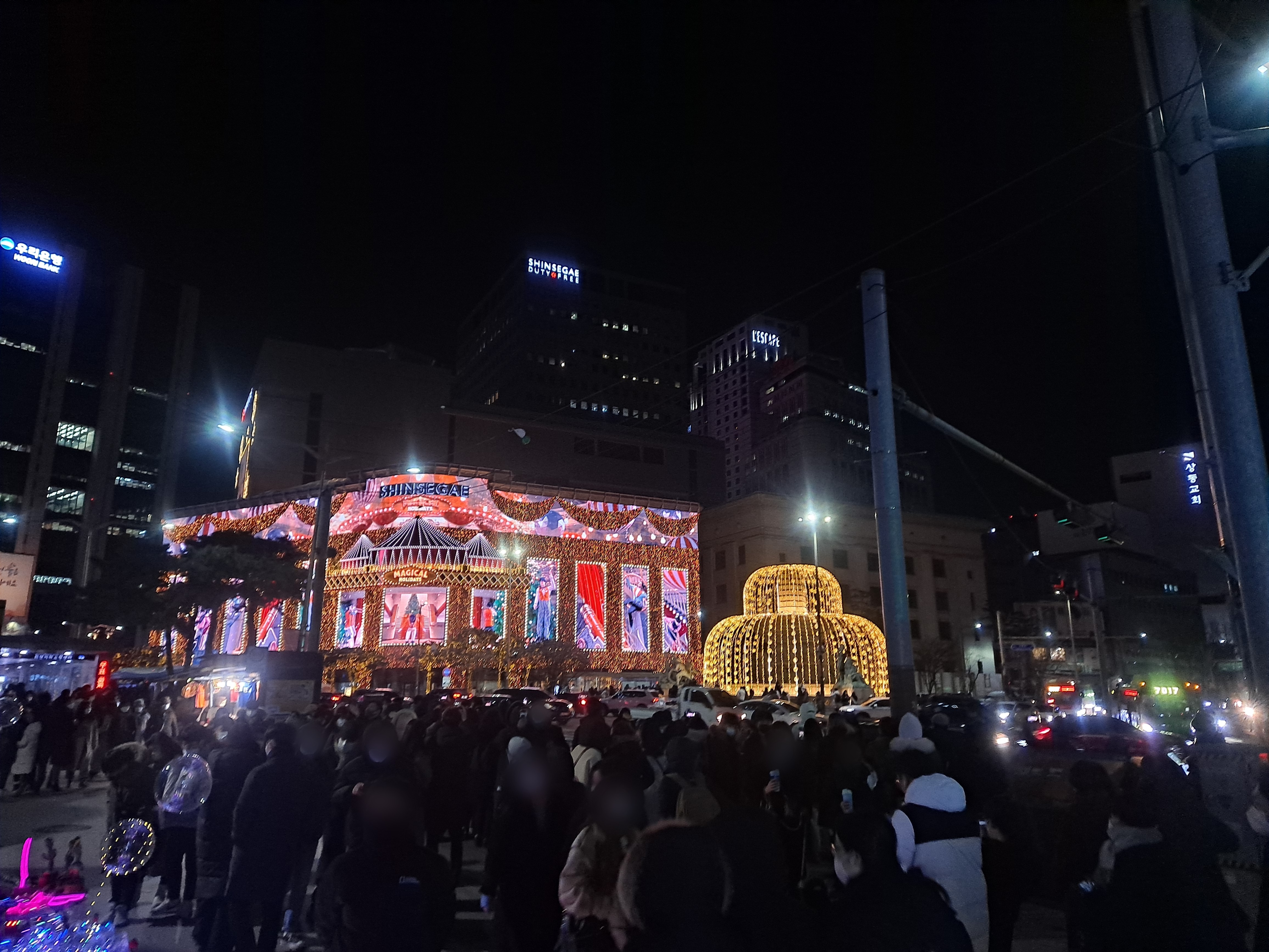 지난 1일 서울 중구 신세계백화점 본점 건너편 서울중앙우체국 앞 공터에 미디어파사드 전시물과 함께 사진을 찍으려는 시민들이 모여있다. 곽소영 기자