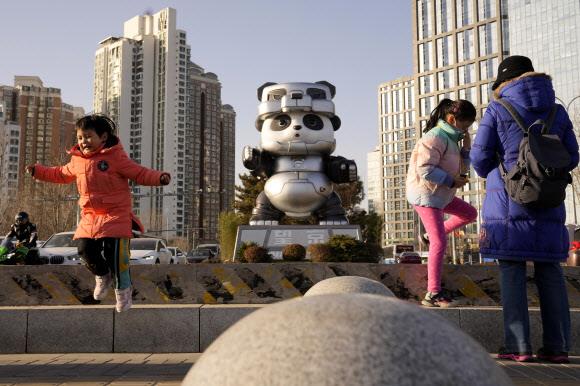 베이징 차오양구 왕징에서 어린이들이 동계올림픽 마스코트인 ‘빙둔둔’을 형상화한 예술 작품 주변에서 즐거운 시간을 보내고 있다. 베이징 AP 연합뉴스