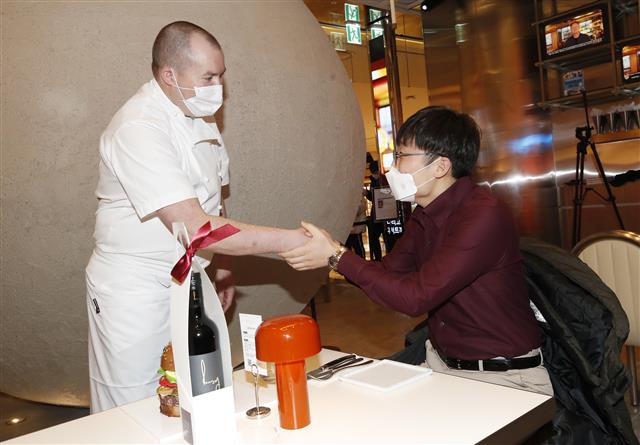 영국 출신 요리사의 햄버거 레스토랑 ‘고든램지버거’ 한국 매장이 7일 서울 송파구 잠실 롯데월드몰에서 아시아 최초로 그랜드 오픈한 가운데 데미안브라셀 셰프가 첫 고객을 맞고 있다. 2022.1.7 뉴스1