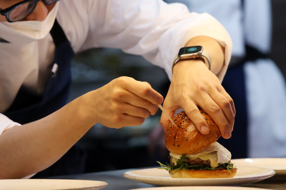 영국 출신의 스타 셰프 고든 램지의 버거 레스토랑인 ‘고든 램지 버거’가 정식 오픈한 7일 오전 서울 잠실 롯데월드몰의 매장에서 직원이 버거를 준비하고 있다. 이번에 내는 매장은 전 세계 4호점이자 아시아 첫 매장이다. 2022.1.7  연합뉴스