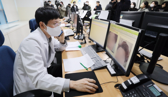 13일 서울 중랑구 서울의료원 코로나19 재택치료관리 상황실에서 의료진이 재택치료 중인 코로나19 환자를 비대면으로 진료하고 있다. 2022.1.13  사진공동취재단