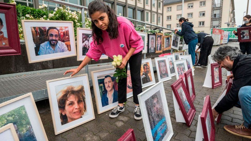 시리아 출신 인권운동가 와파 무스타파가 지난 2020년 6월 4일(현지시간) 독일 코블렌츠 법원에서 고문과 대량 살해 등 반인륜 범죄를 저지른 안와르 라슬란 재판이 처음 열리기 전에 희생자들의 사진을 전시하고 있다. AFP 자료사진 