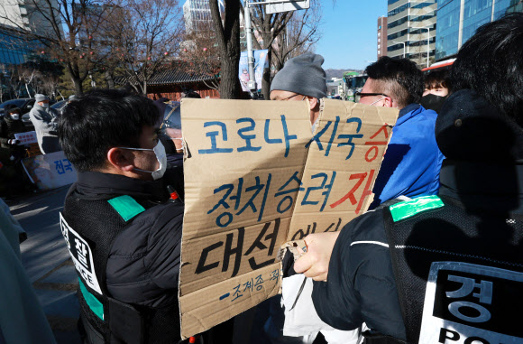 ‘승려대회 취소를 요구하는 불제자’라는 이름으로 모인 승려와 불교 신도들이 13일 오후 서울 종로구 견지동 조계사 앞에서 “코로나 시국에 국민을 불안하게 하는 승려대회를 취소하라”고 요구하며 기자회견을 하던 중 회견 내용에 반대하는 한 승려가 다가와 회견 참석자가 들고 있던 팻말을 뺏어 찢은 뒤 회견 중단을 요구하자 경찰이 이를 제지하고 있다. 2022.1.13  연합뉴스