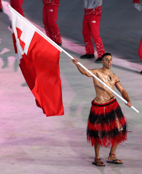 2018 평창동계올림픽 개막식에서 남태평양 섬나라 통가의 크로스컨트리 스키 국가대표 피타 니콜라스 타우파토푸아가 웃통을 벗고 국기를 들고 입장하고 있다. 2018.2.9 로이터