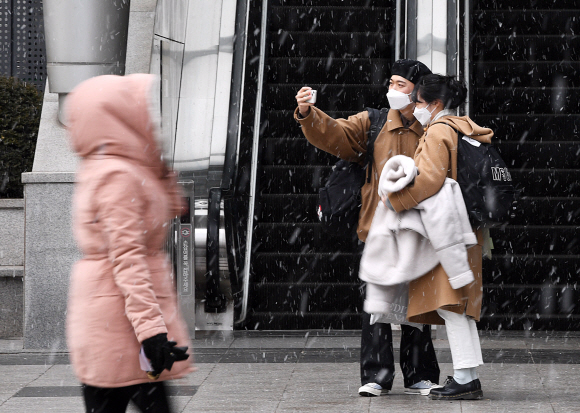 강추위 속 눈이 내리는 17일 오후 서울 용산역 광장 앞에서 시민들이 눈을 맞으며 걷고 있다. 2022.1.17 오장환 기자