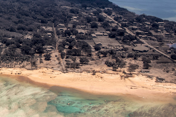 This handout photo taken on January 17, 2022 and received on January 18 from the New Zealand Defence Force shows a view from a P-3K2 Orion aircraft of an area covered in volcanic ash in Tonga, after the eruption of the Hunga-Tonga - Hunga-Haa‘pai volcano on January 15. AFP 연합뉴스