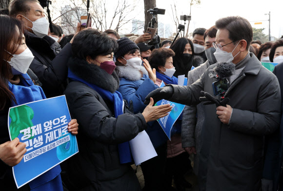 더불어민주당 이재명 대선후보가 22일 서울시 송파구 석촌호수에서 지지자들과 인사하며 이동하고 있다. 2022.1.22 연합뉴스