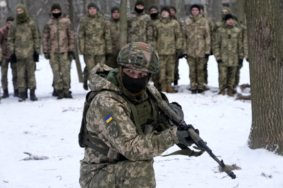 지난 22일(현지시간) 우크라이나 키예프 한 공원에서 우크라이나 국토방위군(TDF) 교관이 부대원들 앞에서 훈련 시범을 보이고 있다. 최근 러시아가 우크라이나 접경에 10만명 이상의 병력을 배치하면서 군사적 긴장감이 고조되고 있다. 키예프 AP 연합뉴스