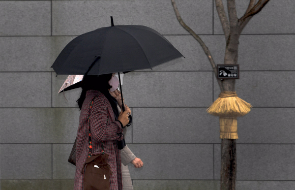 겨울비가 내린 25일 서울 광화문광장에서 시민들이 우산을 쓴채 거리를 걷고 있다. 2022.1.25 박지환기자