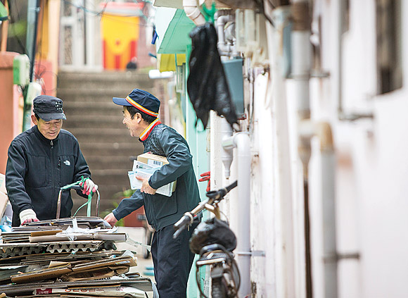 소포를 든 우정사업본부 직원(오른쪽)이 주민과 다정하게 대화를 나누고 있다. 우정사업본부는 고중량 소포 분할접수 시 요금을 깎아주고 서비스 지역을 확대하는 등 배송 서비스를 개선했다. 우정사업본부 제공