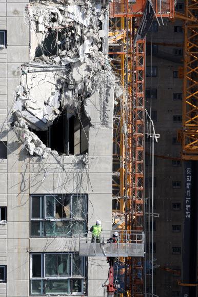 광주 서구 화정아이파크 붕괴 사고 발생 18일째인 28일 오후 크레인에 매달린 바스켓에 탄 공사 관계자들이 안정화 작업을 하고 있다. 2022.1.28  연합뉴스