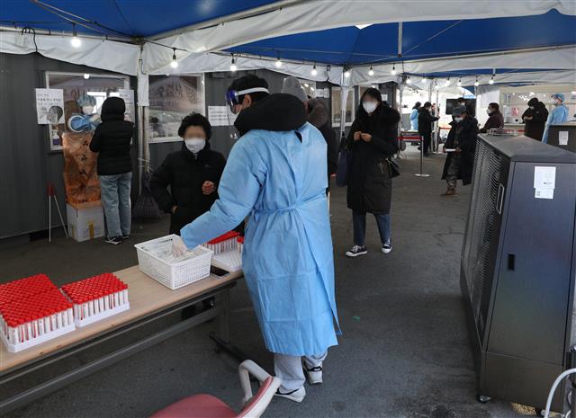 31일 오전 서울역 선별진료소에서 시민들이 코로나19 검체 검사를 받기 위해 줄을 서 있다.                  뉴스1