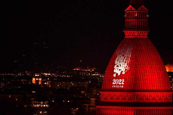 31일(현지시간) 이탈리아 토리노 몰레 안토넬리아나의 돔이 붉은 빛을 반사하는 가운데 한자 ‘복’이 하얗게 빛나고 있다. 토리노 신화 연합뉴스