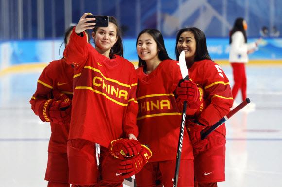 2일 중국 베이징의 우커쑹 스포츠센터에서 중국 여자 아이스하키 대표팀 페이 안나(왼쪽 두 번째)가 자신의 스마트폰으로 팀 동료들과 셀카를 찍고 있다. 베이징동계올림픽에서 모든 선수와 취재진이 의무적으로 써야 하는 스마트폰 앱 ‘마이 2022’에 대한 해킹과 검열 우려가 제기됐다. 베이징 로이터 연합뉴스