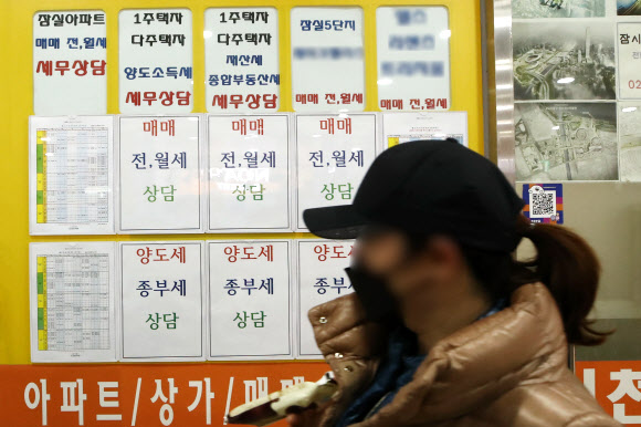 일부 다주택자들이 정부 압박에도 매매 대신 증여를 선택하는 가운데 서울 송파구 부동산 중개업소 앞을 한 시민이 지나가고 있다. 연합뉴스