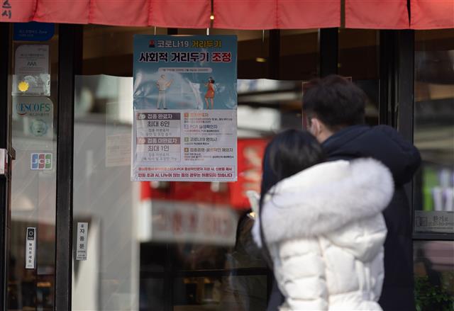 지난 6일 오후 서울 종로구 젊음의거리의 한 음식점에 사회적 거리두기 조정 안내문이 게시돼 있다. 정부는 코로나19 오미크론 변이 확산에 맞춰 현재 실시 중인 사회적 거리두기를 오는 20일까지 2주 연장한다. 접종 여부 구분없이 사적모임은 6명까지만, 식당·카페 등의 운영시간은 오후 9시까지로 제한된다. 2022.2.6 뉴스1
