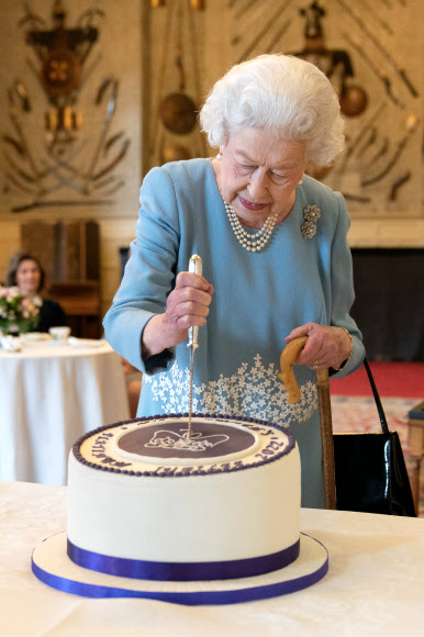 엘리자베스 2세 영국 여왕이 즉위 70주년 하루 전인 5일(현지시간) 샌드링엄 별장에서 열린 축하 행사에서 케이크를 자르고 있다. 여왕은 이날 조촐한 기념식을 가졌다. 샌드링엄 로이터 연합뉴스