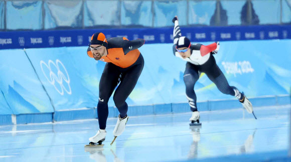 김민석이 8일 오후 중국 베이징 국립 스피드스케이팅 경기장(오벌)에서 열린 2022 베이징 동계올림픽 스피드스케이팅 남자 1500m 경기에서 네덜란드의 키엘드 나위스와 함께 역주하고 있다. 2022.2.8  연합뉴스