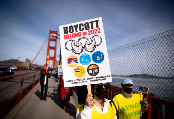 지난 3일(현지시간) 미국 캘리포니아주 샌프란시스코에서 시위대가 2022 베이징 동계올림픽 보이콧을 촉구하는 내용의 팻말을 들고 골든게이트브리지(금문교) 위를 행진하고 있다. 2022.02.09 AFP 연합뉴스