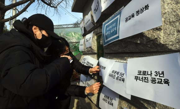 서울시학부모연합과 교육바로세우기운동본부 회원들이 9일 오전 서울 종로구 서울시교육청 앞에서 교육당국의 ‘새학기 학사운영 방안’을 규탄하는 메시지를 붙이고 있다. 서울신문 DB