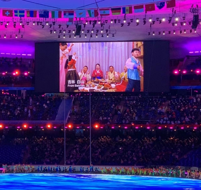 지난 4일 중국 베이징 국가체육장에서 열린 2022 베이징동계올림픽 개회식에서 조선족들이 설 차례상을 나눠 먹는 장면이 대형 화면을 통해 방영되고 있다. 베이징 류지영 특파원