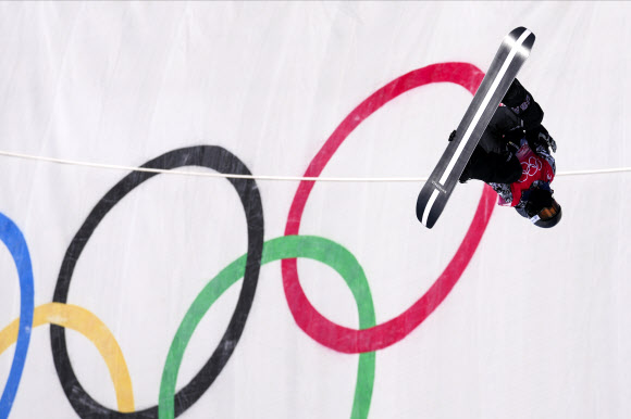 스노보드의 전설’ 숀 화이트가 11일 자신의 마지막 올림픽 경기인 베이징올림픽 남자 스노보드 하프파이프 결선에서 올림픽 마크를 배경으로 공중제비를 돌고 있다. [AP 연합뉴스]
